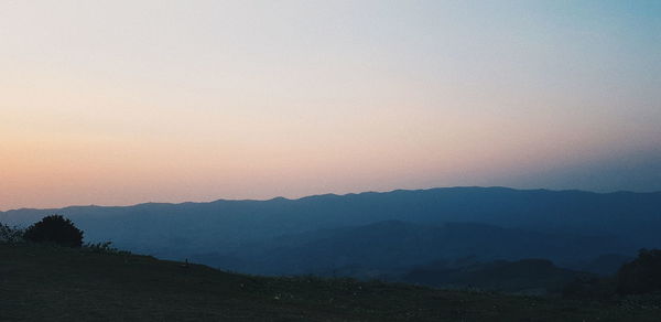 Scenic view of silhouette mountains against sky during sunset