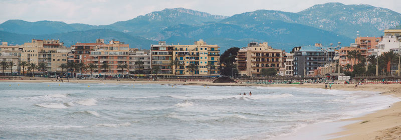 Panoramic view of beach with city in background