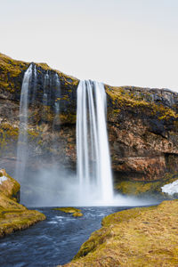 Scenic view of waterfall against clear sky