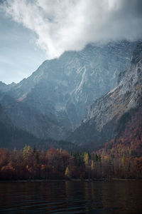 Scenic view of lake by mountains against sky