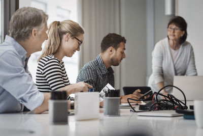 Senior businesswoman giving presentation to colleagues in board room