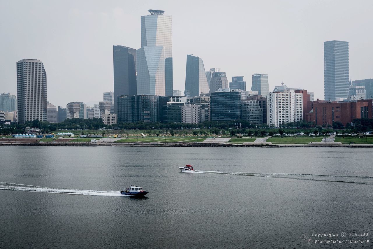 building exterior, city, architecture, built structure, skyscraper, tall - high, transportation, cityscape, office building, urban skyline, tower, modern, mode of transport, city life, river, capital cities, clear sky, financial district, skyline, tree