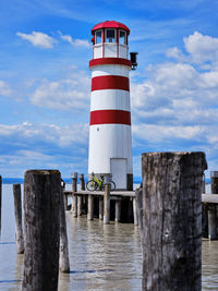 Lighthouse by sea against sky