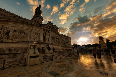 Statue of historic building against sky during sunset