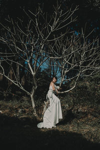 Portrait of woman sitting on tree in forest