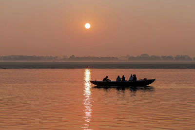 Silhouette of boat on lake at sunset