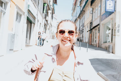 Portrait of woman wearing sunglasses standing in city