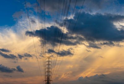 Low angle view of silhouette electricity pylon against sky during sunset