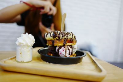 Close-up of hand holding ice cream on table