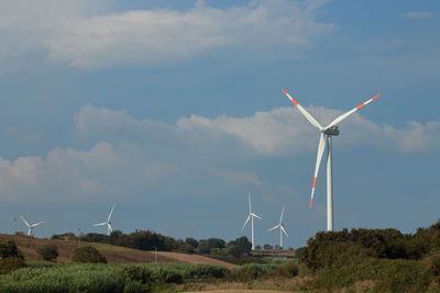 Windmill on field against sky