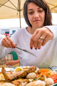 Young woman eating food at restaurant