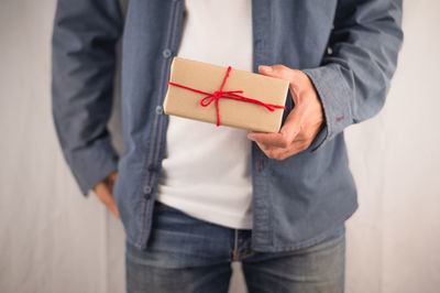 Midsection of man holding mobile phone