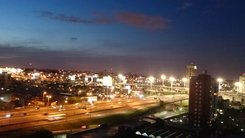 Illuminated cityscape against sky at night