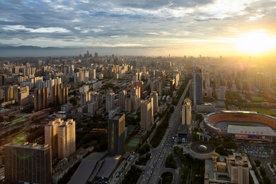 High angle view of illuminated cityscape against sky during sunset