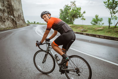 Portrait of man riding bicycle on road