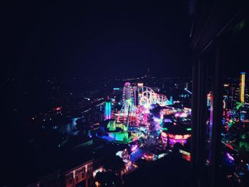 Illuminated cityscape against sky at night