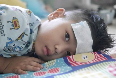 Close-up portrait of cute baby lying on bed