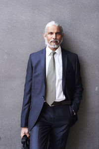 Portrait of senior businessman with grey hair and beard wearing suit and tie