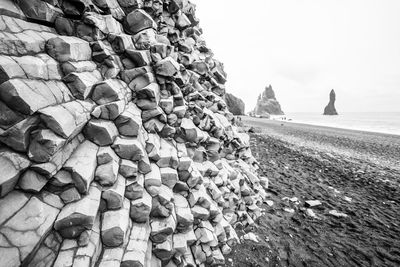 Stack of stones on beach against sky