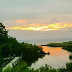 Scenic view of river against sky at sunset