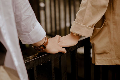 Midsection of couple holding hands