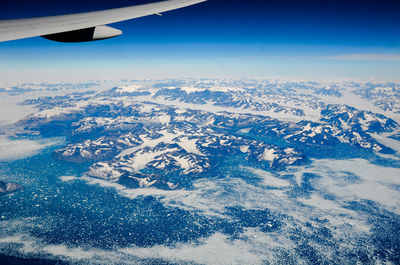 Aerial view of airplane wing over snow landscape