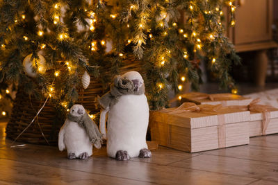 Cute penguin toys under the christmas tree with lights