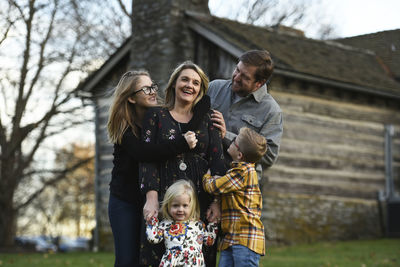 Happy parents with children standing at yard