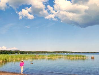 Rear view of man in lake against sky