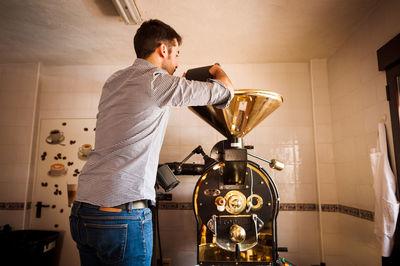 Barista preparing coffee in machinery at cafe