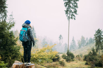 Rear view of man standing against trees