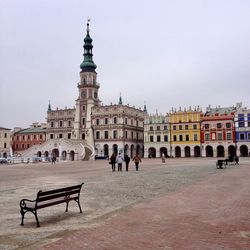 People at town square against buildings against sky