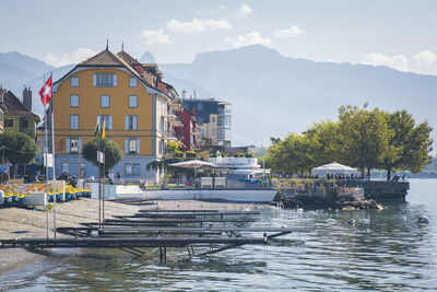 Houses by river against sky