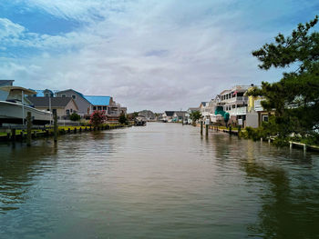 Houses by river against sky