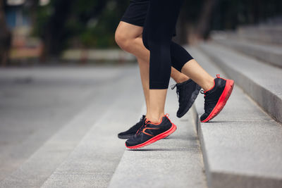 Low section of woman running on street