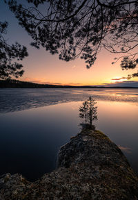 Scenic view of lake against sky at sunset