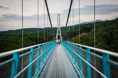 Footbridge over mountain against sky