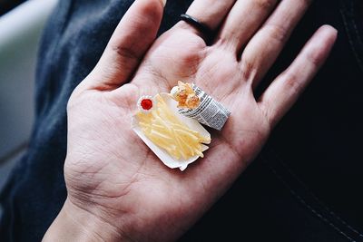 Cropped hand holding artificial food