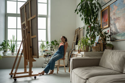 Portrait of woman sitting on sofa at home