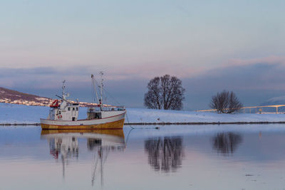 Fishing boat moored on sea against sky