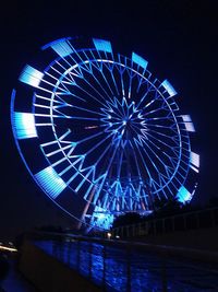 Low angle view of illuminated ferris wheel against sky at night