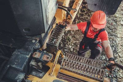 High angle view of worker climbing on truck at construction site