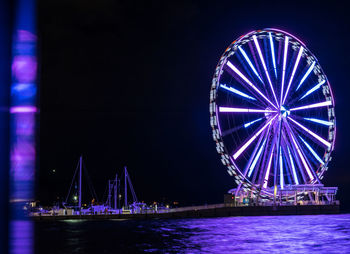 Illuminated ferris wheel at night