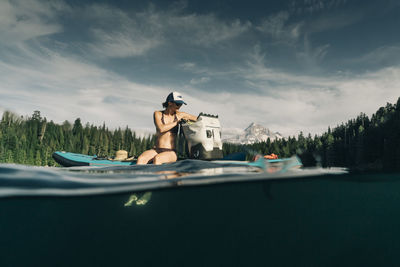 A young woman enjoys a standup paddle board on lost lake in oregon.