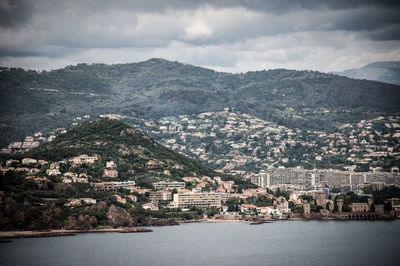 Aerial view of townscape and mountains against sky