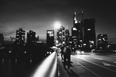 People walking on illuminated city at night