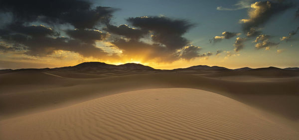 Scenic view of desert against sky during sunset