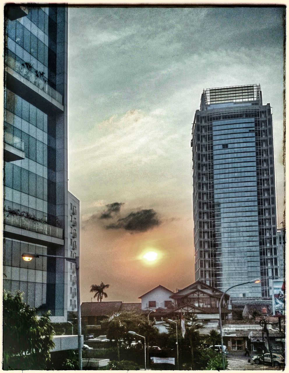 transfer print, building exterior, architecture, built structure, auto post production filter, city, sky, building, low angle view, office building, residential building, modern, window, glass - material, residential structure, skyscraper, sunset, cloud - sky, city life, tree