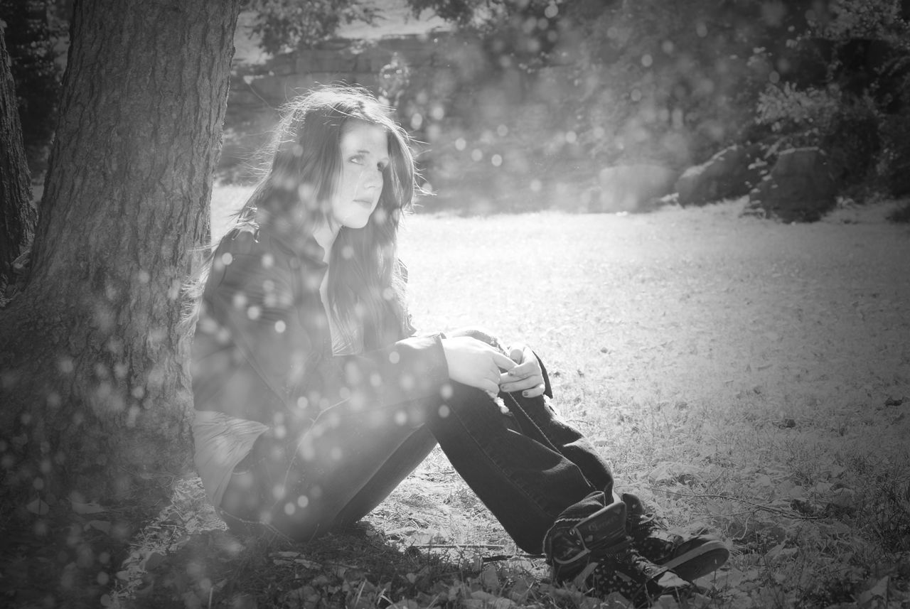sitting, young adult, tree, long hair, one person, one young woman only, one woman only, only women, full length, tree trunk, young women, outdoors, nature, beautiful woman, happiness, adults only, day, beauty, water, people, adult, grass