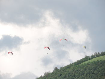 Low angle view of people flying against sky